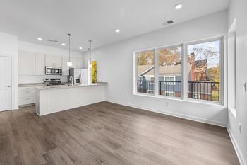 A kitchen with white cabinets and a wooden floor.